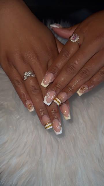 Nude French with gold chain and bow accents